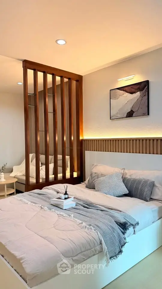 Modern bedroom with stylish decor and cozy ambiance, featuring a wooden partition and elegant lighting.