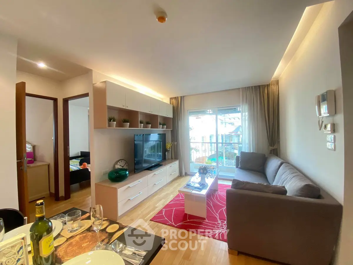 Modern living room with stylish decor and natural light, featuring a cozy sofa and entertainment center.