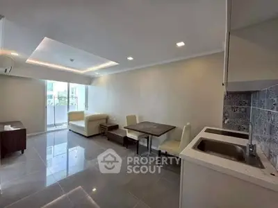 Modern living room with open kitchen and sleek tile flooring