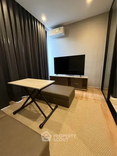 Modern living room with sleek furniture and large TV, perfect for relaxation and entertainment.