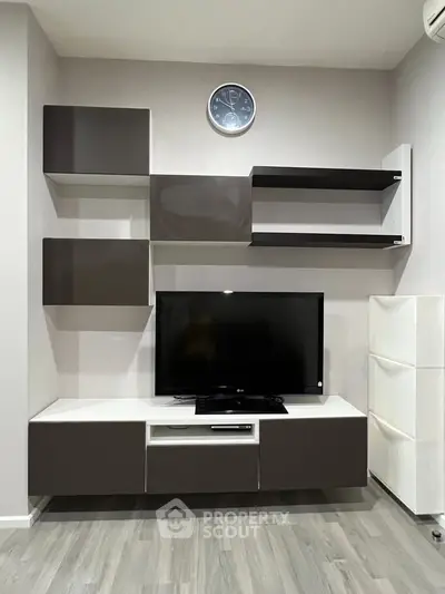 Modern living room with sleek TV unit and wall-mounted shelves