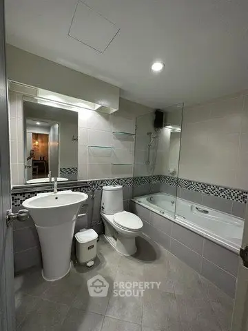 Modern bathroom with sleek fixtures and a bathtub in a contemporary apartment.