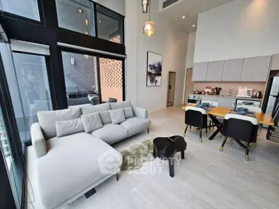 Modern open-plan living room with high ceilings and stylish kitchen