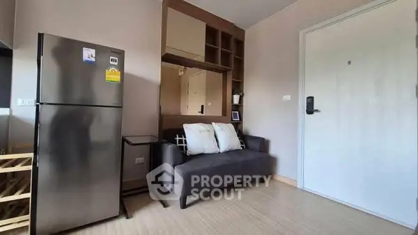 Modern apartment interior with fridge and cozy seating area