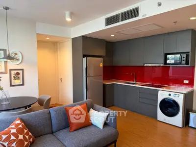 Modern open-layout kitchen with sleek appliances and cozy living area, perfect for urban living.