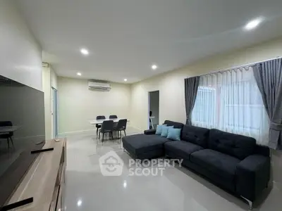 Spacious modern living room with sleek furniture and ample natural light.