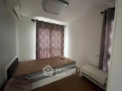 Cozy bedroom with natural light and modern furnishings in a stylish apartment.