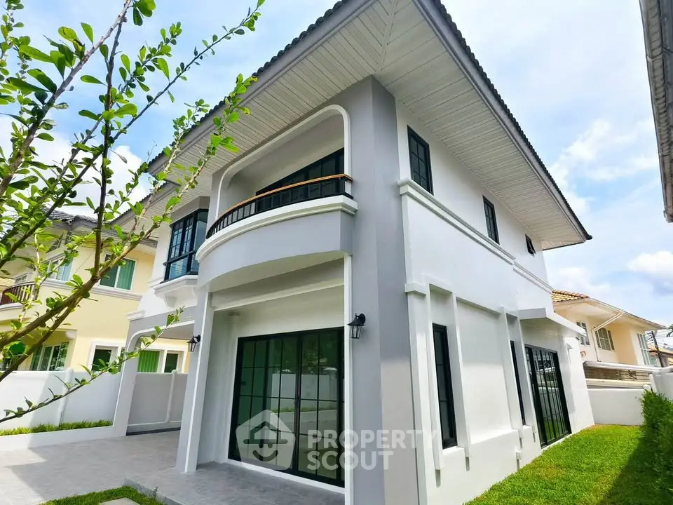 Stunning modern two-story house with large windows and lush green surroundings.