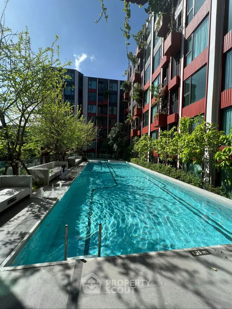 Luxurious apartment complex with a sparkling pool and lush greenery