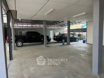 Spacious covered parking area with multiple vehicles in a modern residential building.