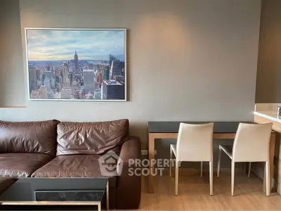 Modern living room with leather sofa and cityscape artwork, featuring sleek dining area and wooden flooring.