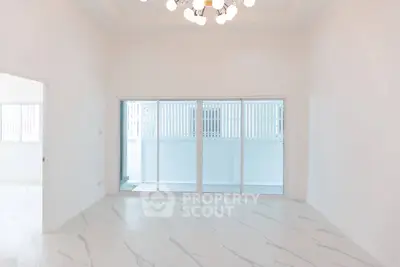 Spacious and bright living room with modern lighting and large sliding doors.