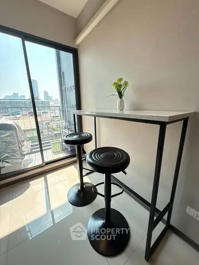 Modern balcony with sleek bar stools and city view, perfect for urban living.