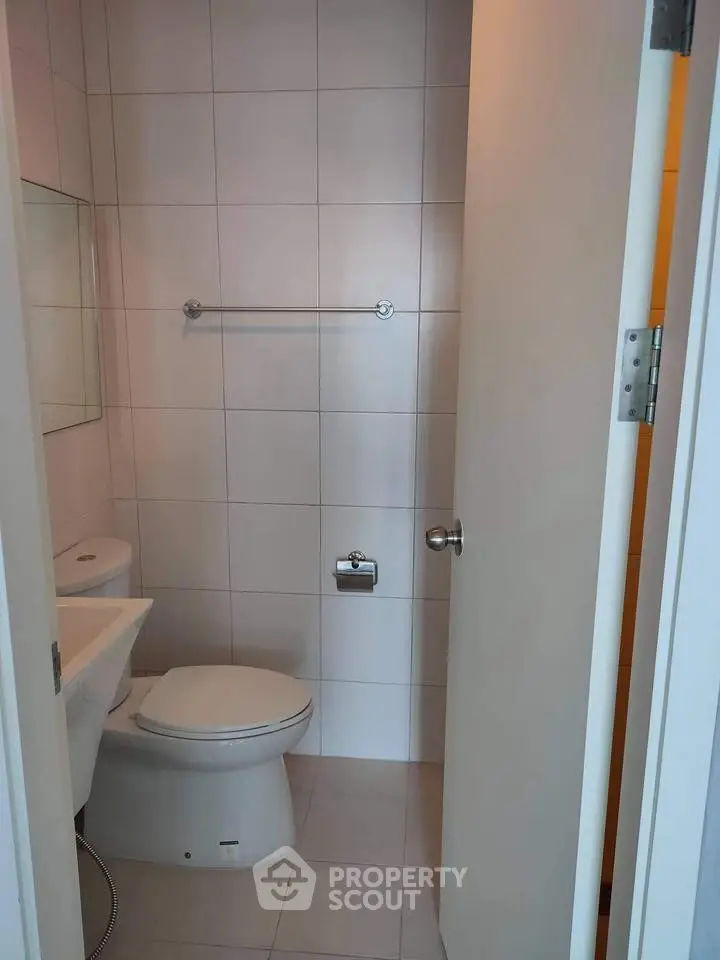 Compact bathroom with modern fixtures and white tiled walls