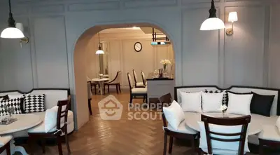 Elegant living room with archway, stylish seating, and chic decor in modern apartment.