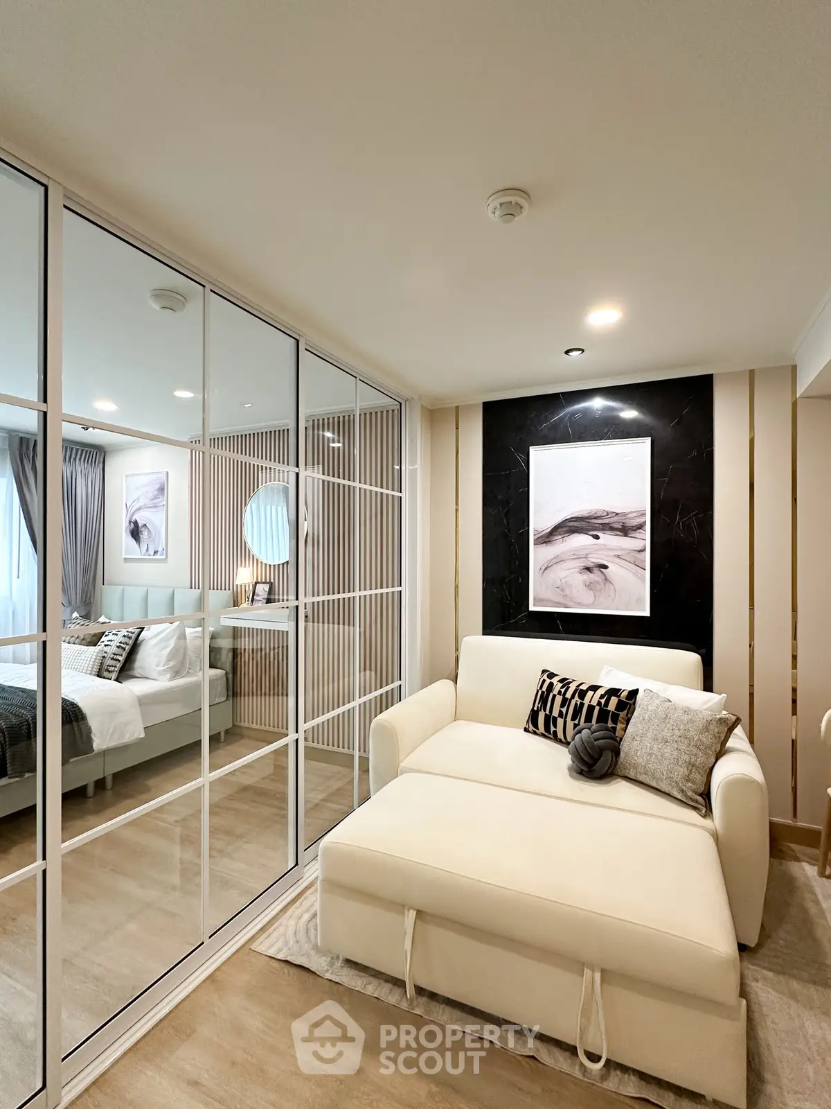 Modern bedroom with mirrored closet and stylish decor in a cozy apartment.