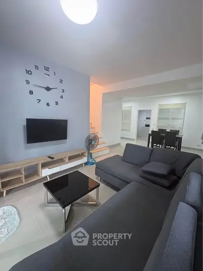 Modern living room with stylish clock and sleek furniture