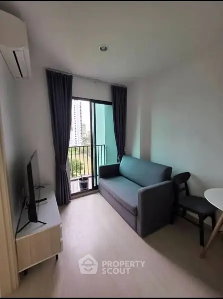 Modern living room with balcony view, featuring sleek furniture and natural light.