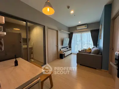 Spacious modern studio apartment with integrated living and sleeping area, featuring wooden flooring, contemporary furniture, and ample natural light.