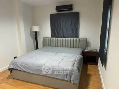 Modern bedroom with stylish bed and wooden flooring