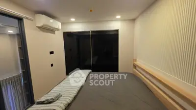 Modern bedroom with sleek design and air conditioning, featuring a large bed and mirrored wardrobe.