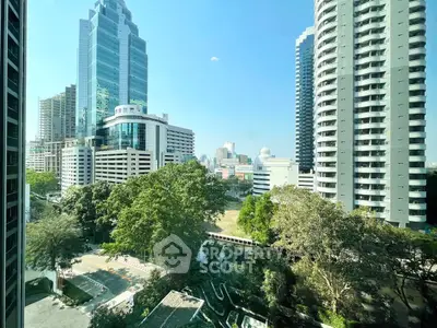 Stunning cityscape view from high-rise building with lush greenery and modern architecture.