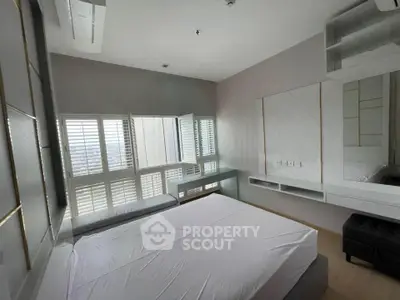 Modern bedroom with large windows and sleek design in urban apartment.