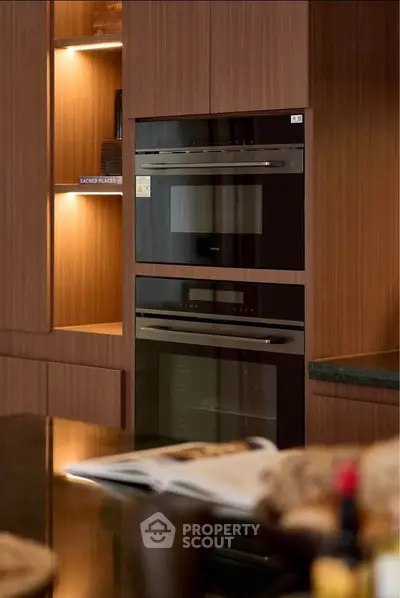 Modern kitchen with built-in oven and sleek wooden cabinetry, perfect for culinary enthusiasts.