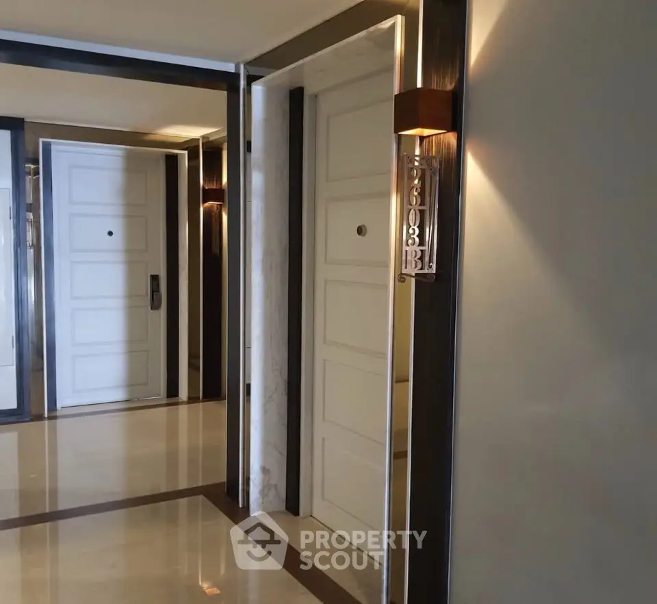 Elegant apartment corridor with modern lighting and sleek door design.