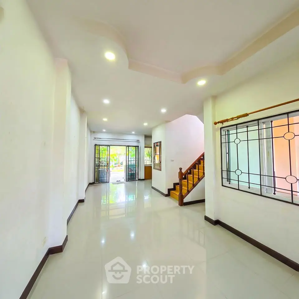 Spacious open-plan living room with modern design and large windows for natural light.