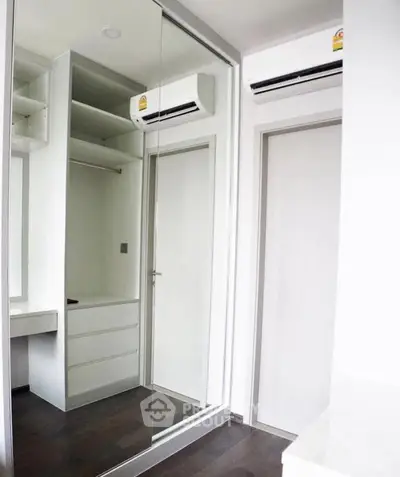 Modern bedroom with mirrored closet and air conditioning unit