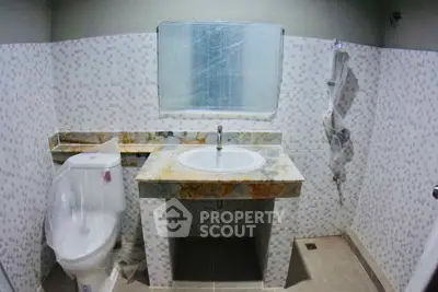 Modern bathroom with marble countertop and tiled walls