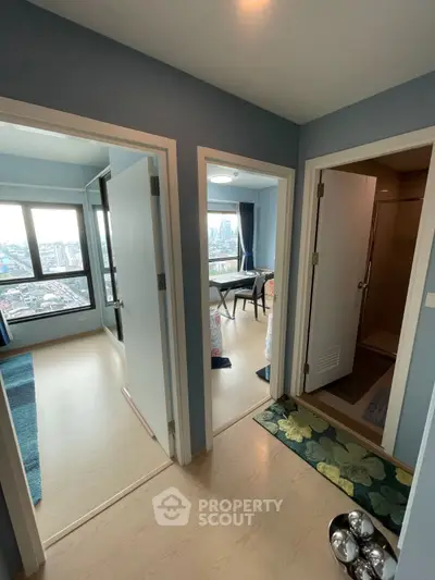Modern apartment hallway with city view from windows, showcasing bright and spacious rooms.