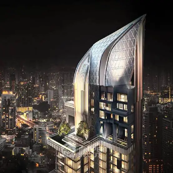 Stunning modern skyscraper with unique architectural design and cityscape view at night.