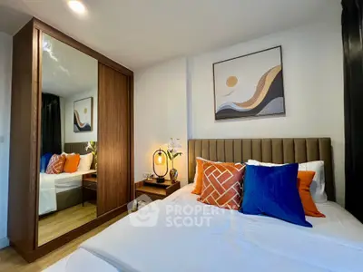 Modern bedroom with stylish decor and mirrored wardrobe