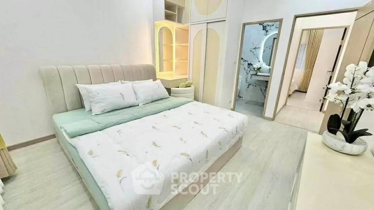Elegant bedroom with modern decor and soft lighting, featuring a plush bed and stylish furnishings.