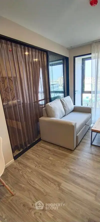 Modern living room with cozy sofa and large windows offering city views