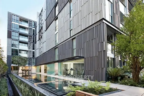 Modern apartment building with sleek design and poolside gym view.