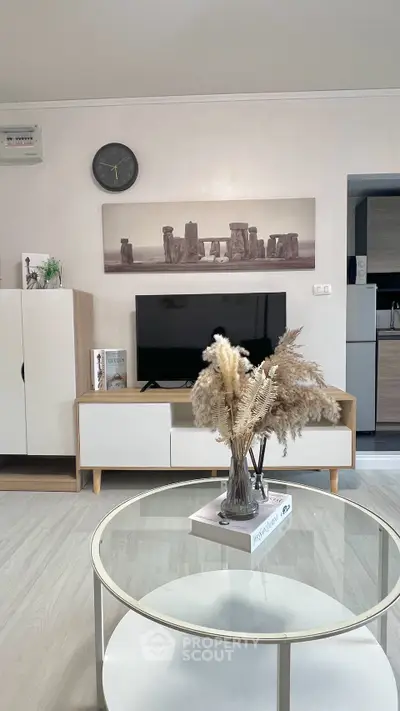 Modern living room with stylish decor and sleek furniture, featuring a TV and elegant wall art.