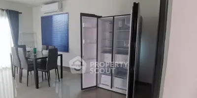 Modern dining area with sleek refrigerator and stylish dining set