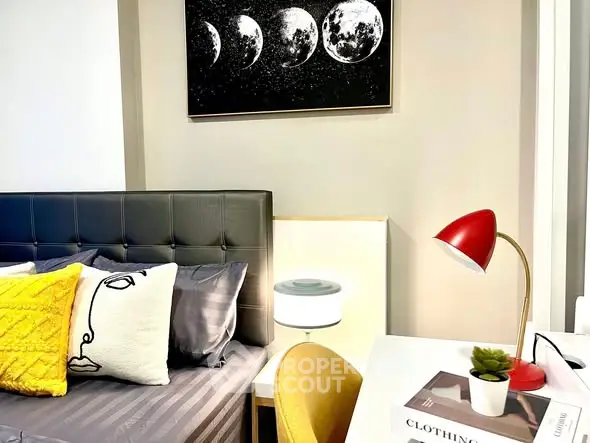 Stylish bedroom with modern decor and cozy ambiance, featuring a chic lamp and artistic wall art.