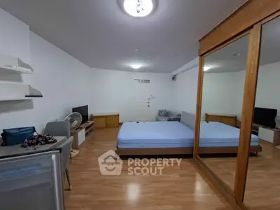 Spacious bedroom with mirrored wardrobe and wooden flooring