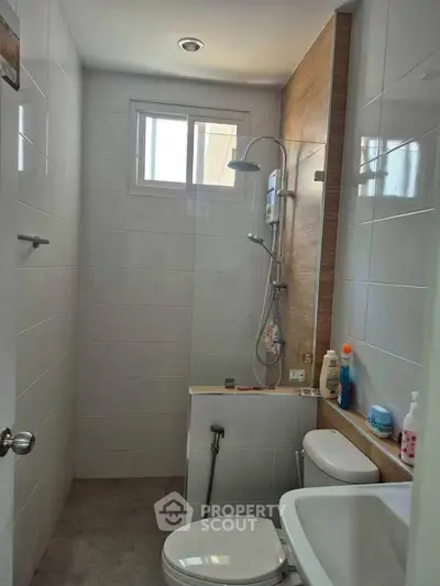 Compact modern bathroom with shower and white tiles