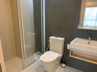 Modern bathroom with sleek shower and contemporary fixtures in a stylish apartment.