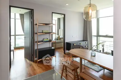 Modern apartment interior with open layout, featuring stylish dining area and cozy living space with city view.