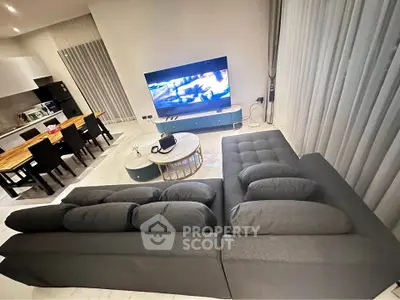 Modern living room with sleek furniture and open kitchen layout, perfect for entertaining.