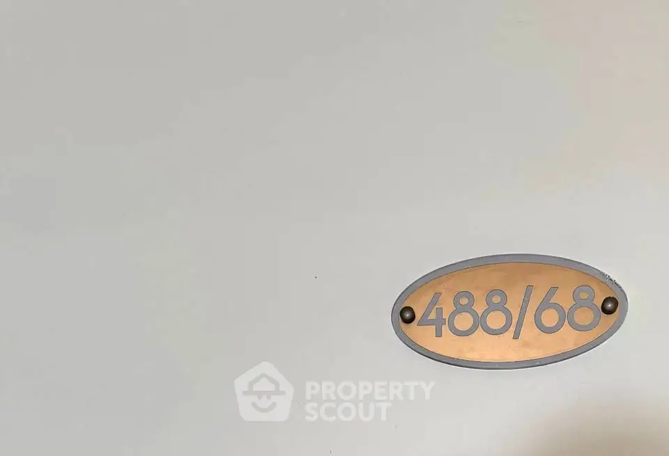 Apartment door with unit number 488/68 on a sleek metallic plaque.