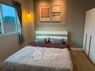 Cozy bedroom with modern decor and scenic window view, perfect for relaxation.
