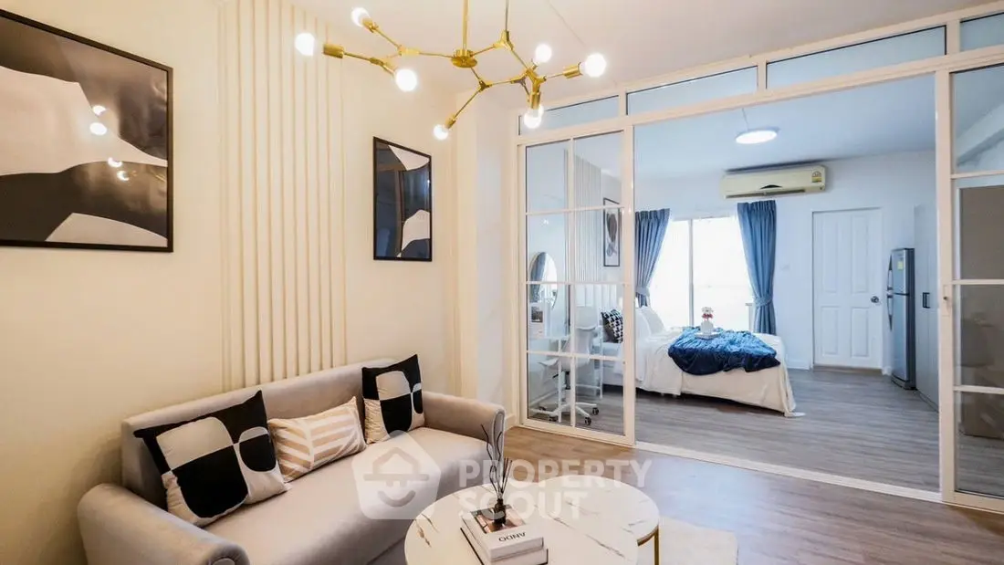 Modern living room with stylish decor and view into cozy bedroom