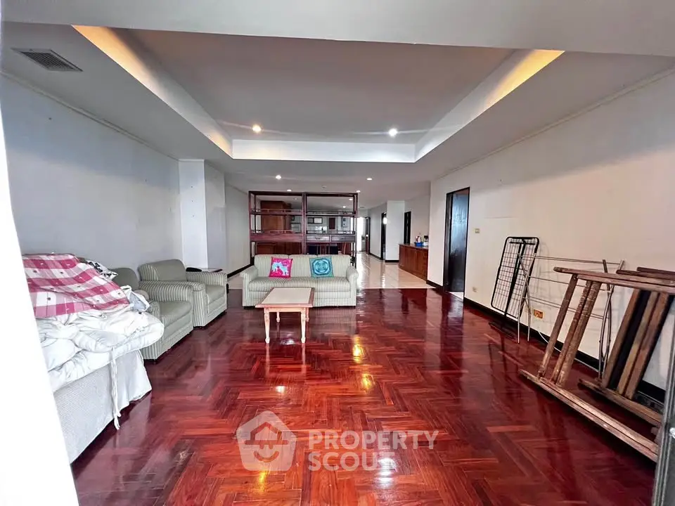 Spacious living room with polished wooden floors and modern furniture